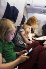 Mother travelling by plane with children — Stock Photo