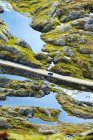 Езда на автомобиле через освещенные солнцем затопленные горные долины — стоковое фото