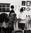 Teenage girl and woman preparing saddle indoors — Stock Photo
