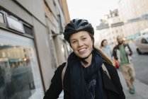 Porträt einer lächelnden jungen Frau mit Helm, Fokus auf den Vordergrund — Stockfoto