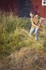Вид сбоку на женщину, стригущую траву — стоковое фото