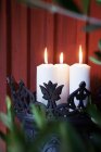 Lit up candles in wrought iron holder — Stock Photo