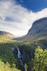 Vista de verdes montañas cubiertas y cascada que fluye - foto de stock