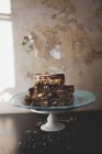 Chocolate cake slices with nuts on cakestand — Stock Photo