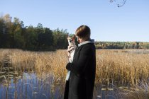 Женщина с собакой в водно-болотных угодьях, сосредоточьтесь на переднем плане — стоковое фото