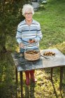 Портрет пожилой женщины, собирающей грибы — стоковое фото