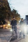 Мужчина и женщина катаются на велосипеде по городской улице, избирательный фокус — стоковое фото