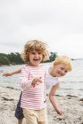 Vista frontal de niña y niño en la playa - foto de stock