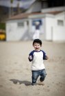 Вид на мальчика, идущего по пляжу — стоковое фото