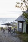 Bicycles near small wooden cottage at seaside — Stock Photo