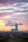 Lighthouse against cloudy sunset sky — Stock Photo