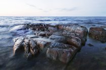 Vue de face des rochers en mer contre le ciel — Photo de stock