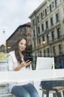 Frau mit Smartphone, Blick aus dem Fenster — Stockfoto