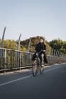 Молода жінка їде на велосипеді, вибірковий фокус — стокове фото