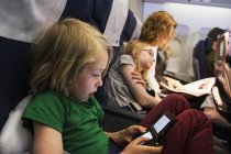 Мать путешествует на самолете с детьми — стоковое фото