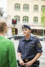 Policewoman talking with man on street, selective focus — Stock Photo