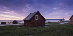 Casas de madera en la orilla del mar durante el atardecer - foto de stock