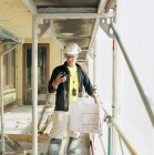Повідомлення будівельника на смартфоні на будівельному майданчику — стокове фото