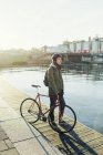 Metà uomo adulto in piedi con bici a scatto fisso sul molo — Foto stock