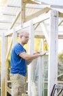 Man building greenhouse, focus on foreground — Stock Photo