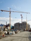 Unfinished building with construction cranes under blue sky — Stock Photo