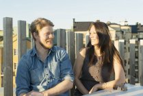 Man and woman sitting by fence — Stock Photo
