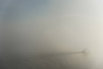 Fähre fährt im Nebel auf geplätschertem Wasser — Stockfoto