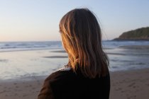 Mulher de pé na praia e olhando para a Baía da Biscaia ao pôr do sol — Fotografia de Stock