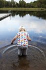 Дівчина стоїть в озері, вид ззаду — стокове фото
