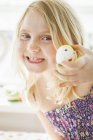 Girl holding egg with smiley face — Stock Photo