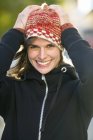 Retrato de jovem mulher usando chapéu de malha e sorrindo — Fotografia de Stock