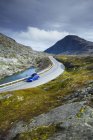 Movimento offuscata auto blu guida lungo sezione tortuosa della strada Trollstigen — Foto stock