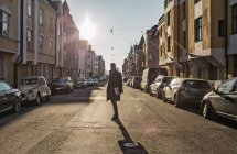 Homem em pé na rua iluminada pelo sol, perspectiva decrescente — Fotografia de Stock