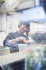 Woman in cafe kitchen, differential focus — Stock Photo