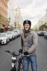 Mann steht mit Fahrrad auf Straße, Fokus auf Vordergrund — Stockfoto