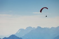 Seitenansicht des Menschen Gleitschirmfliegen in den Bergen in Österreich — Stockfoto