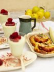 Baked plum pastries and portions of pannacotta — Stock Photo