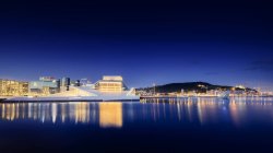 Edificios de la ciudad de Oslo iluminados en la costa por la noche - foto de stock