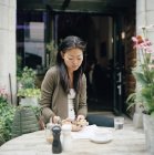 Femme assise au café et messagerie texte — Photo de stock