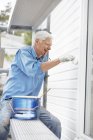 Uomo anziano sorridente pittura muro — Foto stock