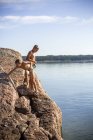 Boys in swimwear on rocks above sea at summer — Stock Photo