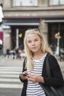 Девушка-подросток, использующая смартфон на улице — стоковое фото