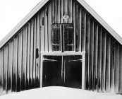 Front view of snowcapped barn, black and white — Stock Photo