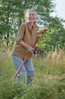 Жіночий фермер різання трави на літо — стокове фото