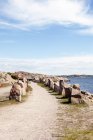 Путь с камнями вдоль морского побережья под голубым небом — стоковое фото