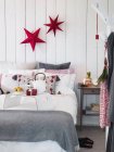 Dormitorio con decoraciones de Navidad y regalo en la cama - foto de stock