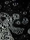 Seifenblasen auf dunkler Oberfläche, Nahaufnahme — Stockfoto