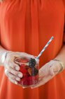 Середня частина жінки тримає склянку фруктового напою — стокове фото