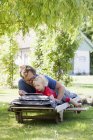 Дочка з батьком, лежачи на лежак і використання планшетного ПК — стокове фото
