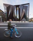 Homme vélo près de l'Université Maritime Mondiale à Malmo, mouvement flou — Photo de stock